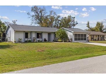 Charming single-story home with a well-maintained lawn and a two-car garage at 20191 Rutherford Ave, Port Charlotte, FL 33952