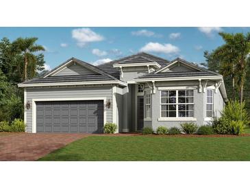 Charming single-story home with a two-car garage, manicured lawn, and beautifully landscaped front yard at 12866 Tulum Loop, Venice, FL 34293