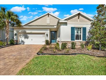 Beautiful single Gathering home featuring a well-manicured lawn and blue shutters in a suburban neighborhood at 13659 Stansil Ave, Odessa, FL 33556