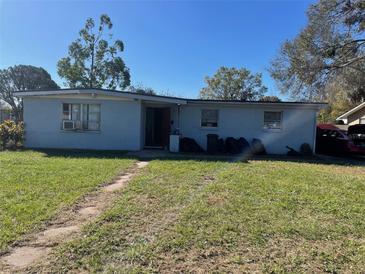 Modest single-story home with a lawn in need of care on a sunny day at 306 5Th Nw Ave, Ruskin, FL 33570