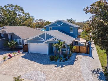 Stunning blue two-story home featuring a brick driveway, well-maintained lawn, and manicured landscaping at 5526 14Th S Ave, Gulfport, FL 33707