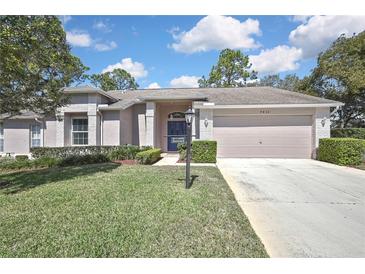 Charming single-story home with a well-manicured lawn and neatly trimmed hedges at 7435 Woodhollow Rd, Spring Hill, FL 34606