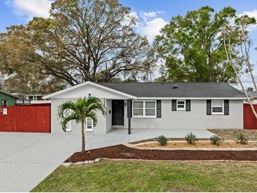 Charming single-story home featuring a gray exterior, well-manicured lawn, and a delightful palm tree in the front yard at 7480 Hobson Ne St, St Petersburg, FL 33702