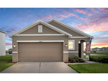 Charming single-story home featuring a two-car garage and a beautifully landscaped front yard at 10864 Penny Gale Loop, San Antonio, FL 33576
