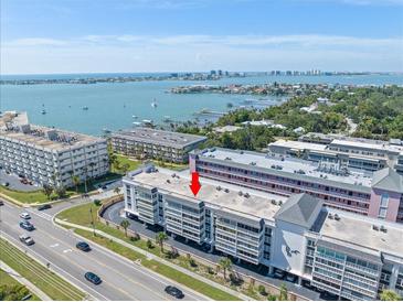 Stunning aerial view of a waterfront condominium complex with views of the bay and cityscape at 131 Bluff View Dr # 409, Belleair Bluffs, FL 33770