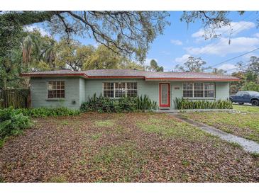 Charming single-story home with a red door and lush landscaping at 1920 E Clifton St, Tampa, FL 33610