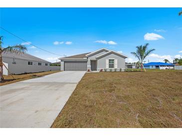 Charming single-story home with gray exterior, two-car garage and a well-maintained lawn at 23343 Van Buren Ave, Port Charlotte, FL 33981