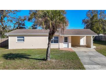 Charming single-story home with a covered carport, neat lawn, and mature landscaping at 39051 Manor Dr, Zephyrhills, FL 33542