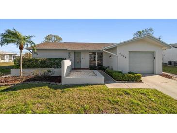 Charming single-story home with a well-manicured lawn, a palm tree, and an attached garage at 4582 Fox Lake Ct, Clearwater, FL 33762