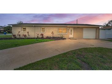 Charming single-story home with an attached garage, driveway, and manicured front lawn at 6310 57Th N Ave, St Petersburg, FL 33709