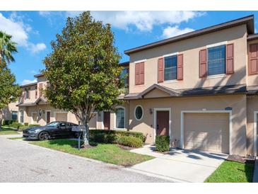 Charming townhome showcasing a well-maintained exterior, manicured lawn, and convenient one-car garage at 10249 Villa Palazzo Ct, Tampa, FL 33615