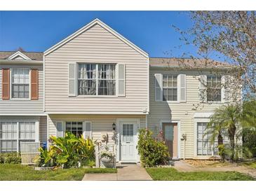 Charming two-story townhouse featuring neutral siding, white trim and a well-manicured front yard with lush landscaping at 16143 Rambling Vine E Dr, Tampa, FL 33624
