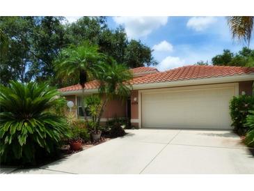Charming single-story home featuring a barrel tile roof, lush landscaping, and a well-maintained two-car garage at 4579 Del Sol S Blvd, Sarasota, FL 34243