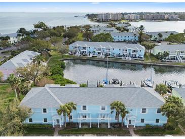 Aerial view of waterfront condos with boat slips, a community pool, and well-maintained landscaping near the bay at 5075 Starfish Se Dr # B, St Petersburg, FL 33705