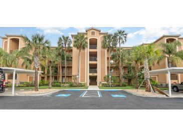 Beautiful condo building featuring multiple balconies and lush landscaping with covered parking spaces at 8403 Grand Estuary Trl # 204, Bradenton, FL 34212