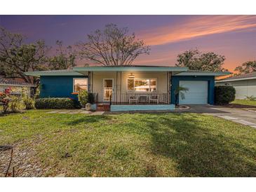Charming single-story home showcasing a quaint porch, lush lawn, and appealing curb appeal at 908 Woodley Rd, Clearwater, FL 33764