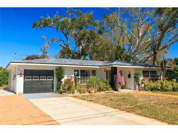 Charming single-story home with a well-maintained lawn, inviting entrance, attached garage and lush landscaping at 1131 60Th Ave S, St Petersburg, FL 33705