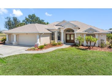 Charming single-story home with lush front lawn and a two-car garage, complimented by manicured landscaping at 182 Rotonda N Blvd, Rotonda West, FL 33947