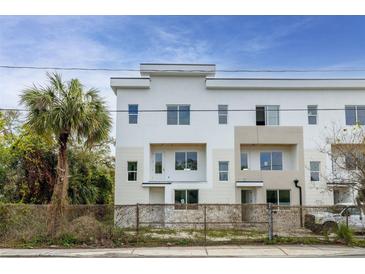 Modern townhouse featuring clean white exterior, balconies, and a nearby palm tree at 3207 N Florida Ave # 1, Tampa, FL 33603