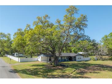 Charming single-story home with mature trees, spacious yard and white picket fence at 4814 Knights Loop, Plant City, FL 33565