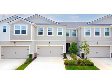 Charming townhome featuring a two-car garage, neutral stucco, and a well-maintained landscaped entrance at 5736 Grand Sonata Ave, Lutz, FL 33558