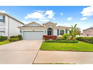 Charming single-story home featuring lush landscaping, a two-car garage, and a welcoming entrance at 12503 Candleberry Cir, Tampa, FL 33635