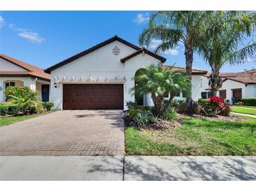 Charming home with a well maintained front yard, brick driveway, and a two-car garage at 16868 Scuba Crest St, Wimauma, FL 33598
