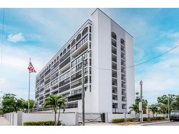 Modern condominium building with a white facade, multiple balconies and an American flag in the front yard at 3211 W Swann Ave # 502, Tampa, FL 33609