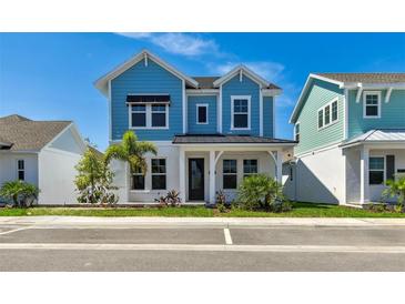 Charming blue two-story home featuring manicured landscaping and a welcoming front porch at 7258 Kodiak Ln, Sarasota, FL 34240