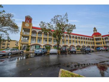 Multi-story apartment building with a clock tower, parking, and arched walkways at 2430 Florentine Way # 44, Clearwater, FL 33763