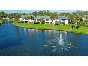 Charming waterfront condo building with balconies overlooking a serene pond and fountain at 3001 58Th S Ave # 312, St Petersburg, FL 33712