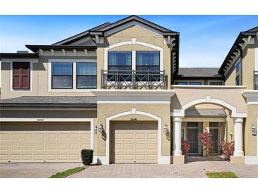 Charming townhome showcasing a private balcony, garages, and well-maintained landscaping at 30045 Southwell Ln, Wesley Chapel, FL 33543