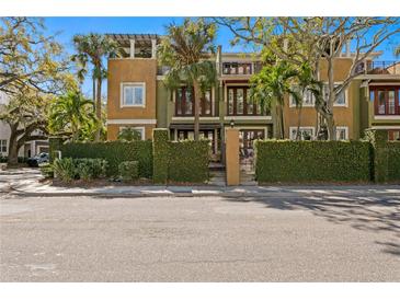 Charming multi-story townhome with lush landscaping and a private gated entrance on a sunny day at 4907 Bayshore Blvd # 115, Tampa, FL 33611