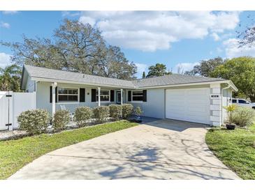 Charming single-story home featuring a well-manicured lawn, classic shutters, and attached two-car garage at 1015 Coldstream Ct, Tarpon Springs, FL 34689