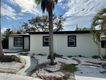 Side view of this single Gathering home, showcasing black trim around windows, minimalist landscaping, and a contemporary design at 3934 Huntington Ne St, St Petersburg, FL 33703