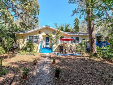 Charming single-Gathering home with a colorful exterior, blue stairs, and a cozy patio seating area at 5029 29Th S Ave, Gulfport, FL 33707