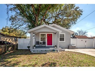 Charming single-story home with a bright pink front door and well-maintained landscaping at 6907 N 12Th St, Tampa, FL 33604