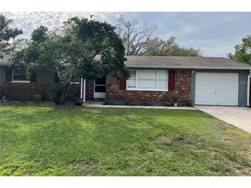 Charming single story home with brick facade, red shutters, and a well-maintained lawn at 16240 Lake Palm Dr, Lutz, FL 33549