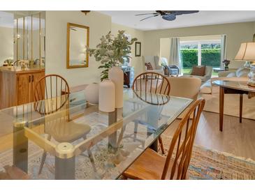 Bright dining room featuring a glass table and views into the living room at 3401 Stonehaven E Ct # A, Palm Harbor, FL 34684