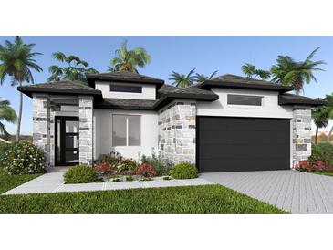 Charming single-story home featuring stone accents, a two-car garage, and lush tropical landscaping at 3724 109Th Street East, Palmetto, FL 34221