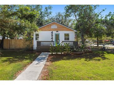 Charming one-story home with a manicured lawn, light blue door, and inviting front porch at 4944 28Th S Ave, Gulfport, FL 33707
