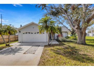 Charming single-story home with a two-car garage, complemented by well-maintained landscaping and mature trees at 80 Squire Ct, Dunedin, FL 34698