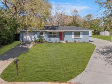 Charming single-story home boasts a manicured lawn, light blue siding, and a striking red front door at 1996 Hyvue Dr, Clearwater, FL 33763