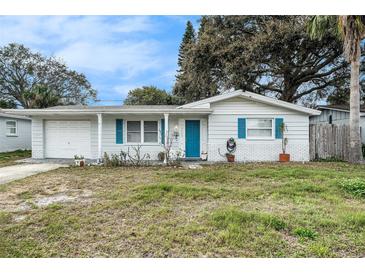 Charming single-story home featuring a well-maintained lawn, vibrant blue door, and freshly painted white accents at 3649 Bradford Dr, Holiday, FL 34691