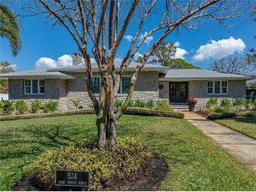 Beautiful stone house with mature landscaping, sidewalk, and a well-manicured green lawn at 524 Park S St, St Petersburg, FL 33707