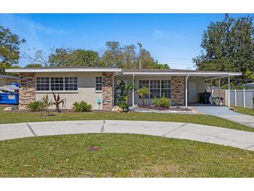 Charming single-story home featuring stone accents, a carport, and well-maintained landscaping at 8006 N Ola Ave, Tampa, FL 33604