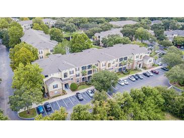 Aerial view of condo complex featuring lush landscaping, ample parking, and well-maintained buildings at 10205 Courtney Palms Blvd # 304, Tampa, FL 33619