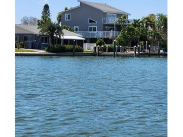 Waterfront two-story home featuring a private dock and a beautiful view of the serene open water at 17404 1St E St, Redington Shores, FL 33708