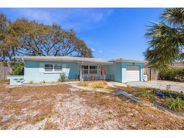 Charming single-story home featuring a blue exterior, attached garage and some mature trees at 1751 8Th Sw Ave, Largo, FL 33770