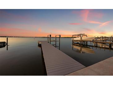 A dock on the water at sunset, complete with boat lift and stunning colorful skies at 1843 Bayou Grande Ne Blvd, St Petersburg, FL 33703